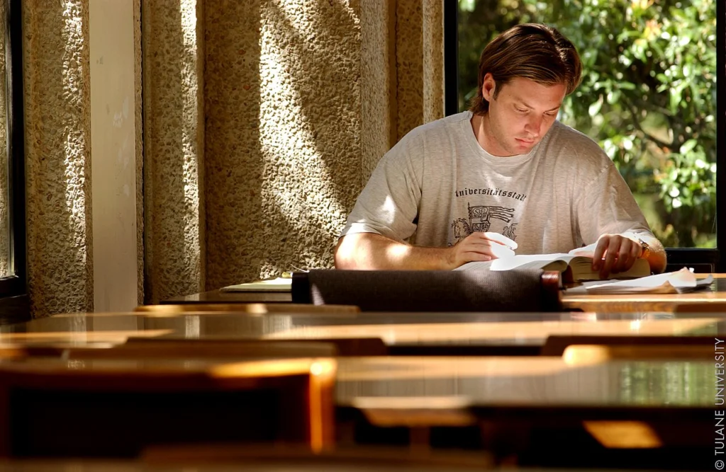 Student uczy się w czytelni biblioteki uniwersyteckiej