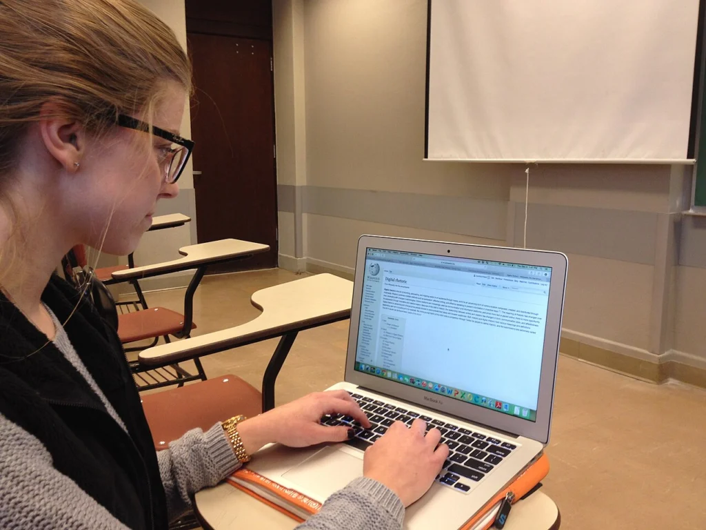Studentka pisze na laptopie w sali